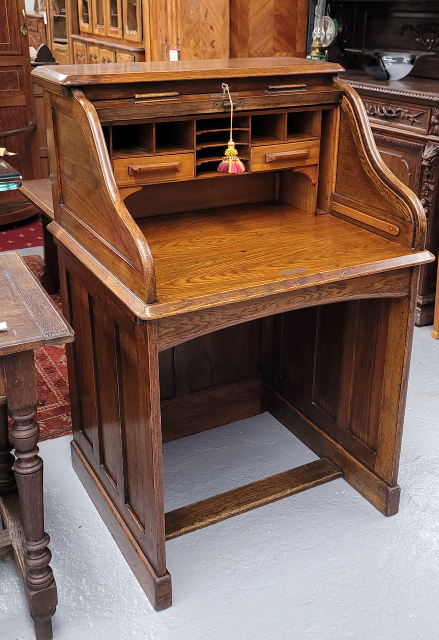 Charming petite English Oak fitted roll top desk. It has a very lovely fitted interior and a drawer at the front ideal for a unit or apartment. Sourced locally and in good original detailed condition.