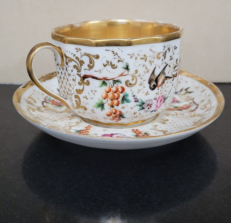 “Old Paris Porcelain” large cup and saucer, beautifully decorated with birds, grapes, floral sprays and heavily gilded. Dated to base 1835. In good original condition please view photos as they help form part of description.