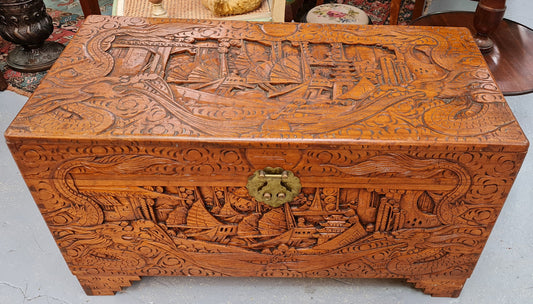 Vintage nicely carved Camphor wood chest. It has amazing carvings of boats, dragons and temples. It is in good original detailed condition.