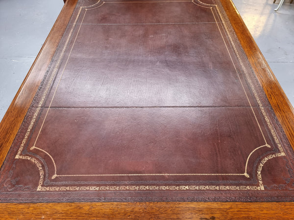 Substantial French Louis XVI style Oak partners desk. It has a beautiful leather top, two drawers on either side and decorative carvings throughout. Sourced from France and in good original detailed condition.