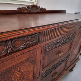 Art Deco Tudor style Oak sideboard with decorative carved detail. Plenty of storage space with two cupboards and four drawers. It has been sourced locally and is in good original detailed condition.