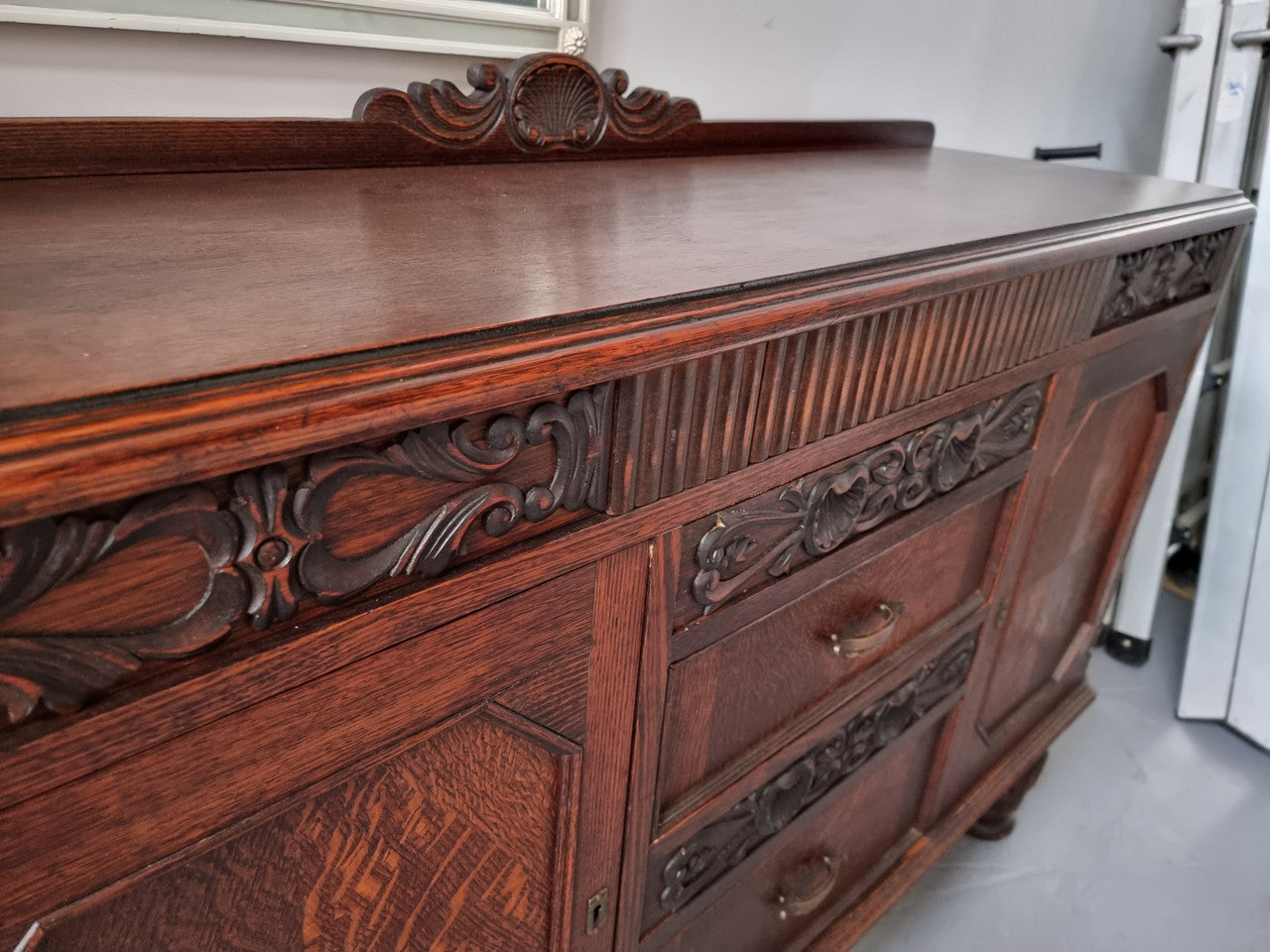 Art Deco Tudor style Oak sideboard with decorative carved detail. Plenty of storage space with two cupboards and four drawers. It has been sourced locally and is in good original detailed condition.
