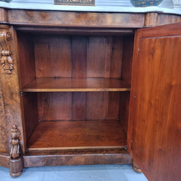 An elegant Antique Victorian Burr wood Walnut marble-top sideboard credenza with a mirrored center door. It has a white shaped marble top, mirror front, nicely carved details and three swing doors along with two keys. It is in good original detailed condition.