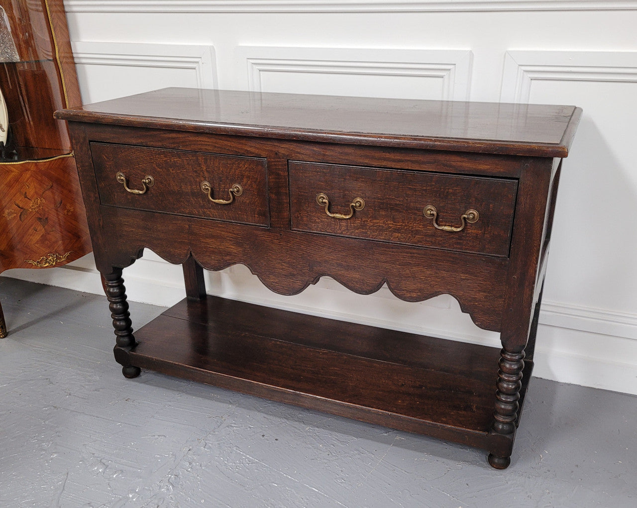 Rare size 19th Century English oak dresser base. It has two good size drawers and amazing patina. It has been sourced from France and in good original detailed condition.