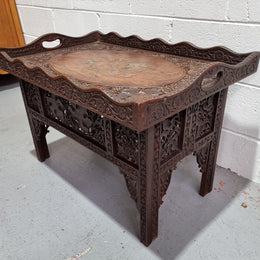 Anglo Indian folding occasional table with lift-up tray top. The tray has brass inlay and ornate carvings. The bottom of the table folds down and it is in good original condition.