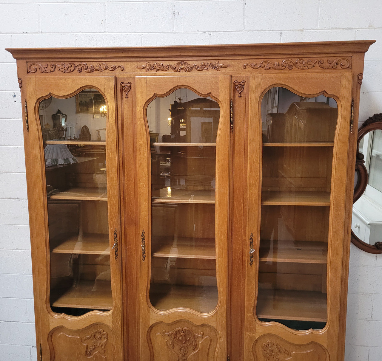 French Louis XV style light Oak three door bookcase with five fixed shelves. It has lovley glass doors and has been sourced from France. Is in good original detailed condition