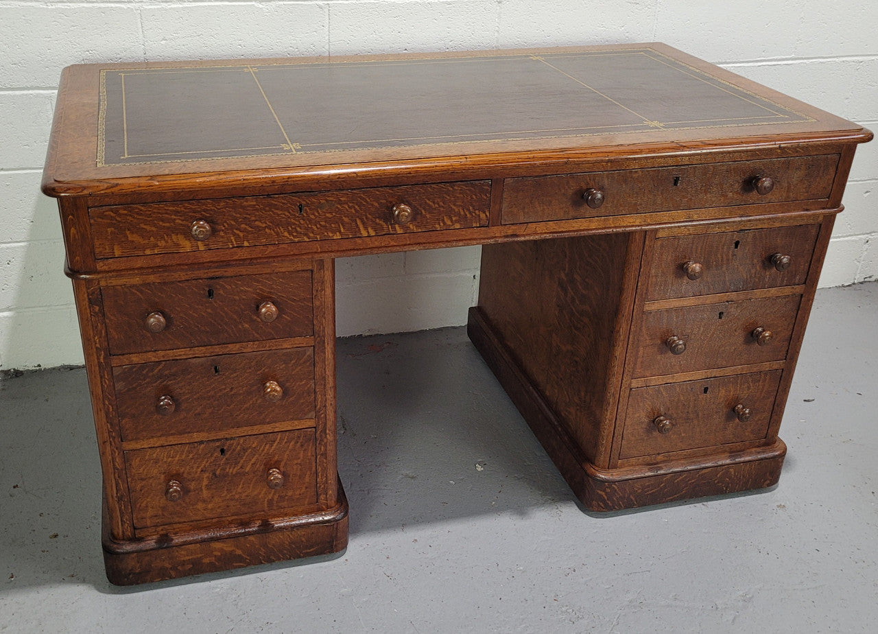 English Oak double pedestal desk with a tooled leather top . It has eight drawers in total and is in good original condition.