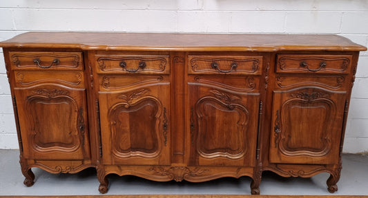 A Beautifully carved French Walnut Louis XV style four door sideboard. Plenty of storage space with four doors as well as four drawers. It is in good original detailed condition.