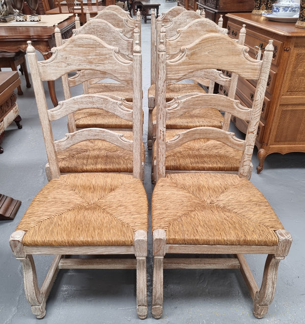 Rustic set of eight French limed rush seat dining chairs. They are very sturdy and solid. Wide sit making them comfortable to sit in and are in original condition.