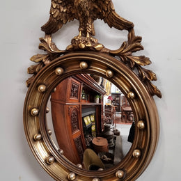 Vintage gilt framed convex mirror featuring carved eagle. It has been sourced from France and is in good original condition, please view photos as they help form part of the description.