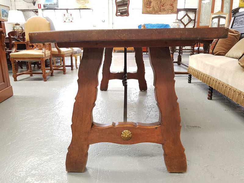 French Oak Spanish style dinner table with beautiful simple iron work underneath. Table top is in good original condition with character marks and has a wax finish. Circa 1930.