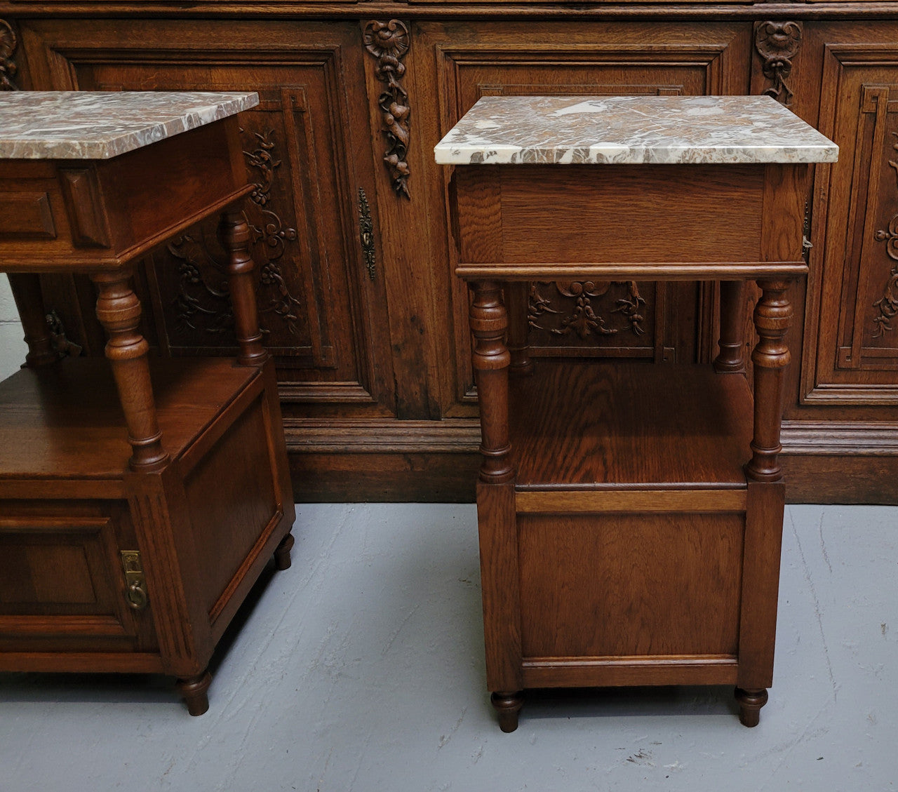 Pair of French Antique Oak marble top bedsides Henry II style. They have a drawer, cupboard and an open shelf for all your storage needs. They have been sourced from France and are in good original detailed condition.