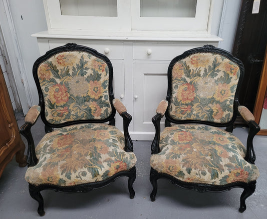 Antique 19th century Louis XV style ebonized upholstered armchairs. The fabric is in good used condition showing signs of use. They can be used as is or reupholstered for a new look.