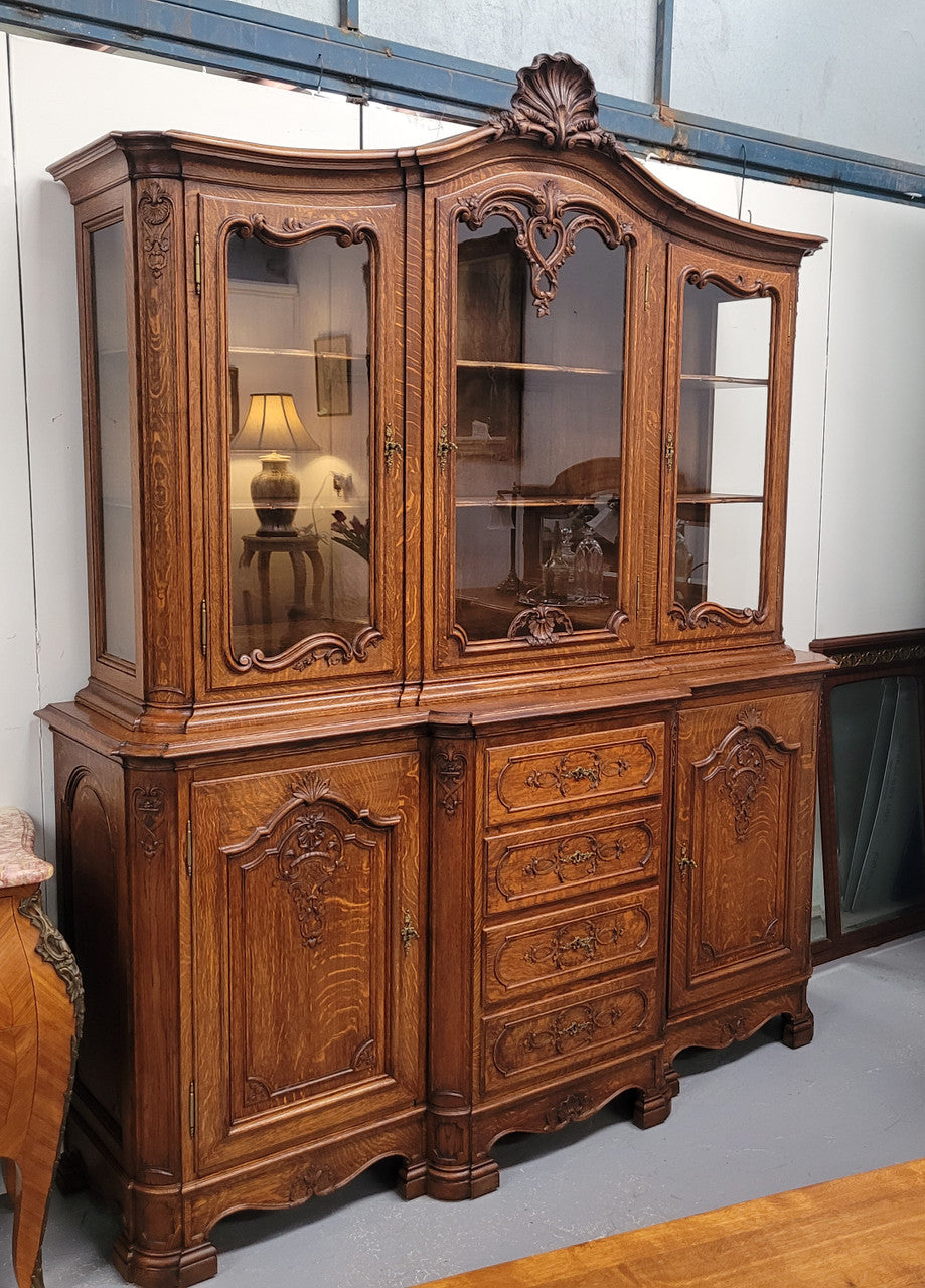 Impressive French Oak Louis 14th Style Display and Sideboard. It has 4 drawers, 2 bottom cupboards with 6 total shelves and 3 display doors with 3 shelves.  In good, detailed condition.