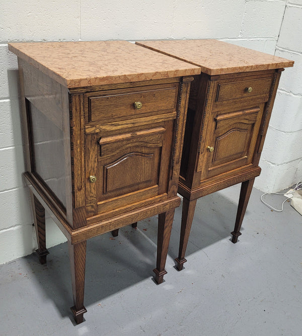 Beautiful pair of French oak bedside cabinets with marble tops. They have a drawer and cupboard for storage and are in good original detailed condition.