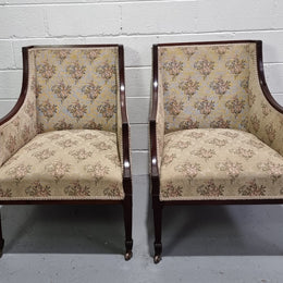 Pair of Regency style wing back armchairs with original castors and tapestry upholstery. They are in good original detailed condition.