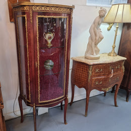 French Mahogany two shelf vitrine with curved glass and brass mounts. It has a lovely frabic interior and two glass shelves. In good original detailed condition.