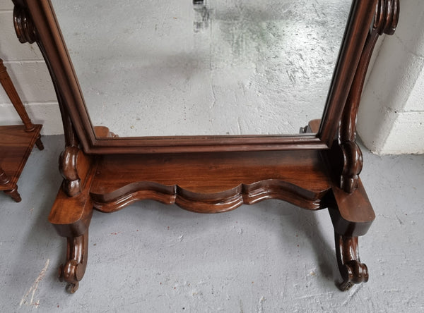 Antique Victorian 19th Century full length Mahogany cheval mirror. Mirror supported on two elegant scrolled upright support and stands on moulded base with four scrolled feet and castors.