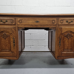 Fabulous French oak carved partners desk with a lovely parquetry top. It has three drawers and two cupboards on one side and two cupboards on the other side with no functioning drawers. It is in good original detailed condition.