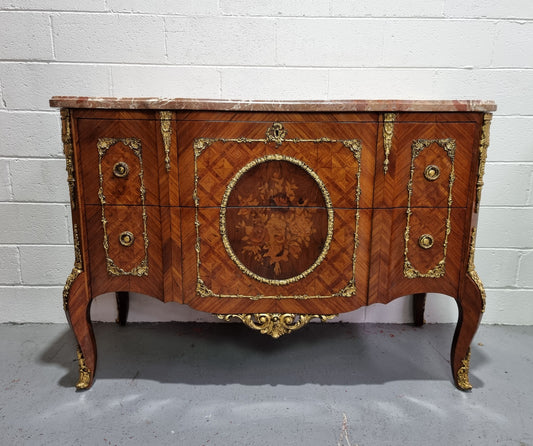 Stunning transitional French Marquetry inlaid marble top commode. It has lovely ormolu decorative mounts and an amazing thick marble top. Sourced from France and is in good original detailed condition.