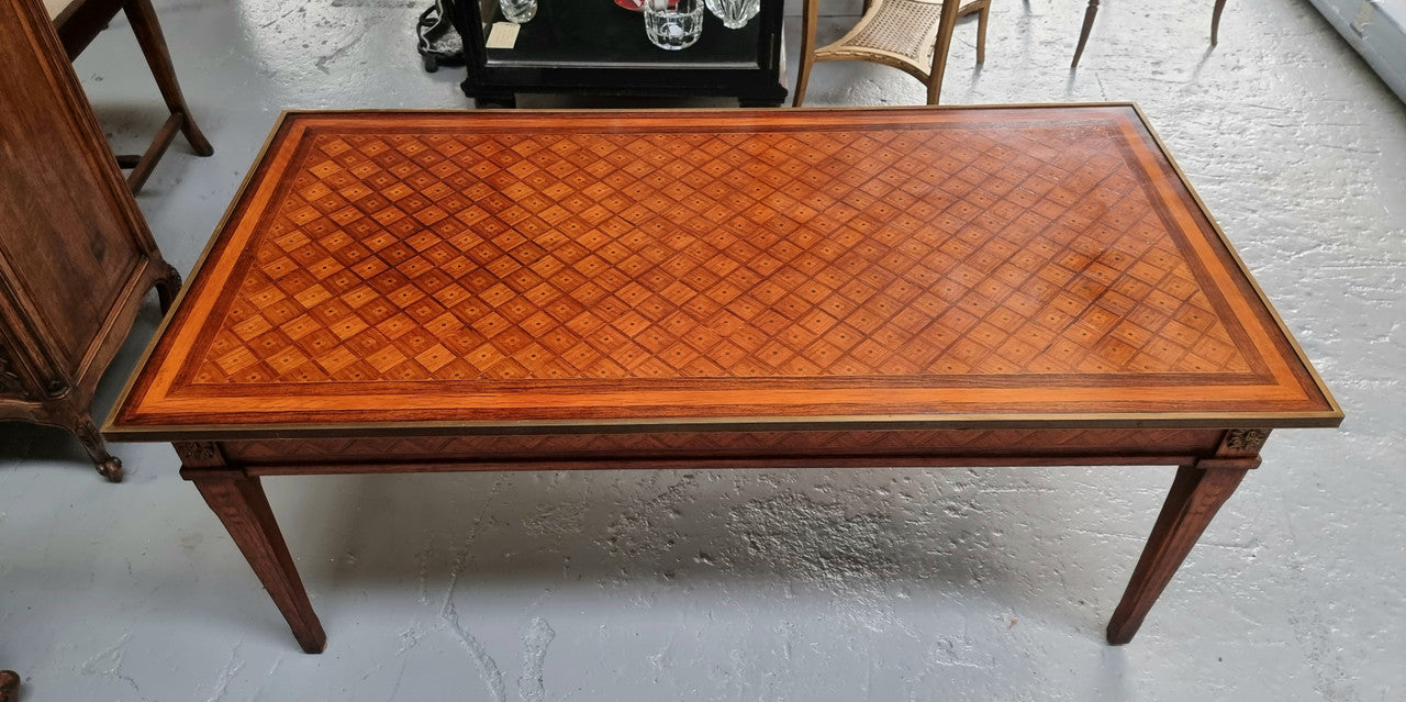 Beautiful French Louis XVI style inlaid coffee table with a brass band and glass top. In good original detailed condition.