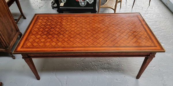 Beautiful French Louis XVI style inlaid coffee table with a brass band and glass top. In good original detailed condition.