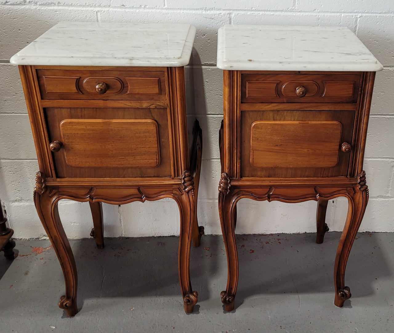 Pair of stunning Louis XV style French Walnut white marble top bedside cabinets. They have one drawer and a cupboard that is marble lined. The marble has been polished and they are in good original detailed condition.