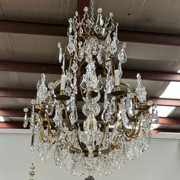 Louis XV 18th Century important cage shaped Castle Chandelier with 12 bronze scones and adorned with 8 daggers and large cut crystal prisms and the barrel threaded with cut glass pieces and finished with a large glass ball. The chandelier has beautiful proportions and is very well balanced in its arrangement of the crystals etc. The chandelier was sourced from Paris and comes with the majority of its original crystals intact. There are 6 internal lights and combined with the 12 sconces offers a dazzling arr