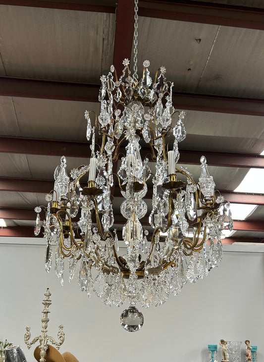 Louis XV 18th Century important cage shaped Castle Chandelier with 12 bronze scones and adorned with 8 daggers and large cut crystal prisms and the barrel threaded with cut glass pieces and finished with a large glass ball. The chandelier has beautiful proportions and is very well balanced in its arrangement of the crystals etc. The chandelier was sourced from Paris and comes with the majority of its original crystals intact. There are 6 internal lights and combined with the 12 sconces offers a dazzling arr
