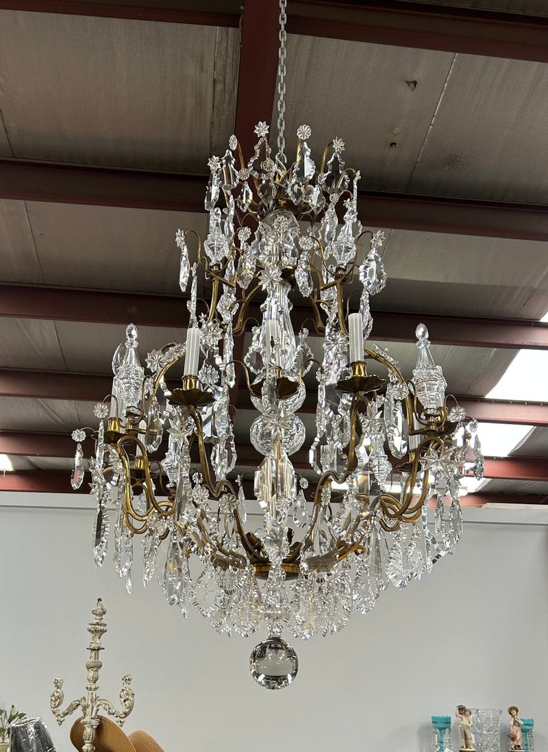 Louis XV 18th Century important cage shaped Castle Chandelier with 12 bronze scones and adorned with 8 daggers and large cut crystal prisms and the barrel threaded with cut glass pieces and finished with a large glass ball. The chandelier has beautiful proportions and is very well balanced in its arrangement of the crystals etc. The chandelier was sourced from Paris and comes with the majority of its original crystals intact. There are 6 internal lights and combined with the 12 sconces offers a dazzling arr