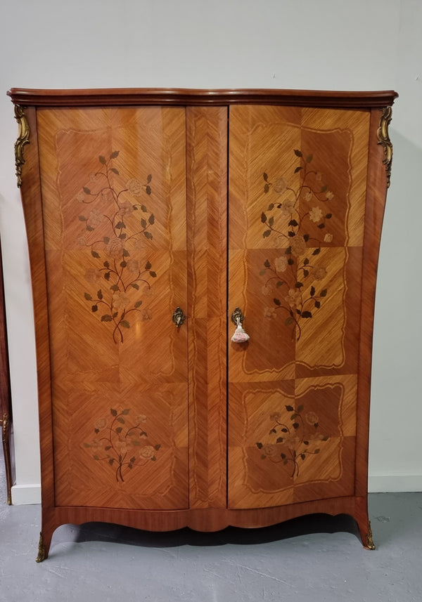 Tall French Marquetry inlaid armoire / bookcase with ormolu mounts. The interior has six fully adjustable shelves and two drawers. It is in good original detailed condition.