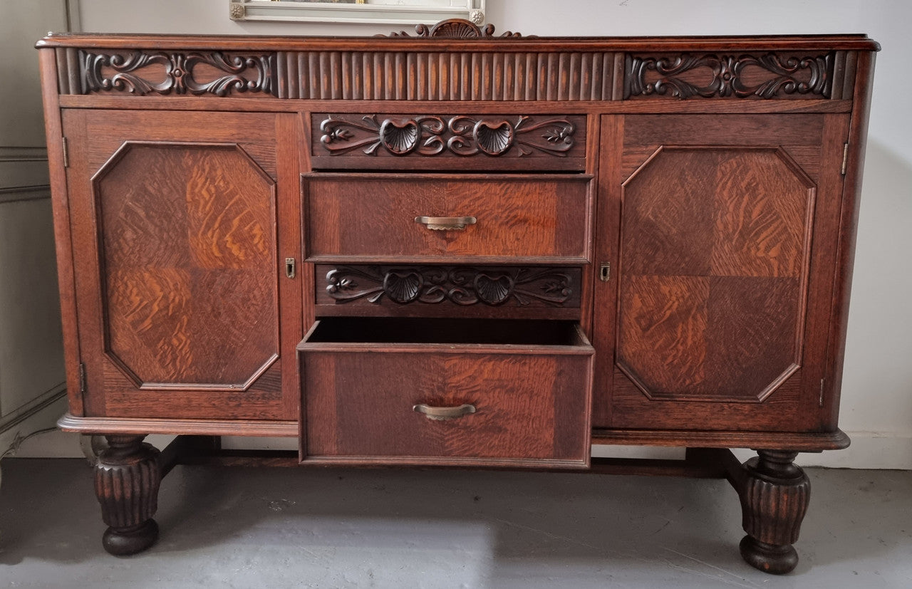 Art Deco Tudor style Oak sideboard with decorative carved detail. Plenty of storage space with two cupboards and four drawers. It has been sourced locally and is in good original detailed condition.