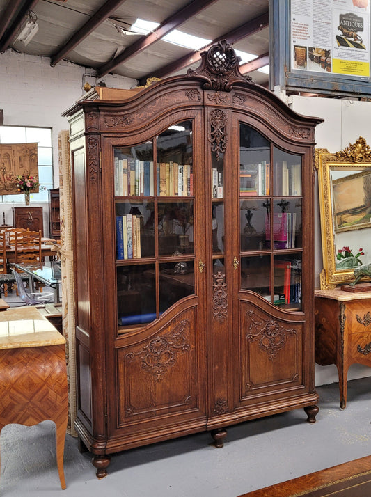 Substantial French Oak Louis 15th Style large two door bookcase. Adjustable shelves and very decorative carving. In good original detailed condition.