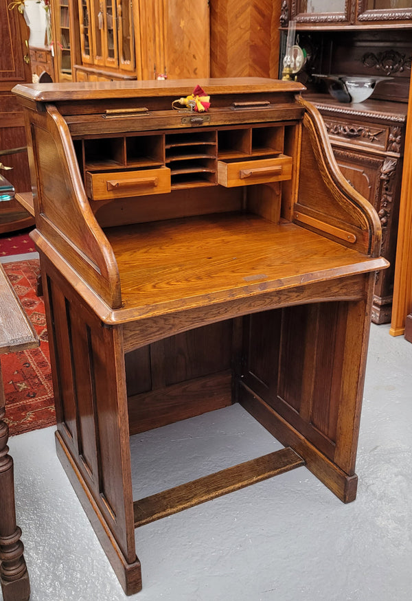 Charming petite English Oak fitted roll top desk. It has a very lovely fitted interior and a drawer at the front ideal for a unit or apartment. Sourced locally and in good original detailed condition.