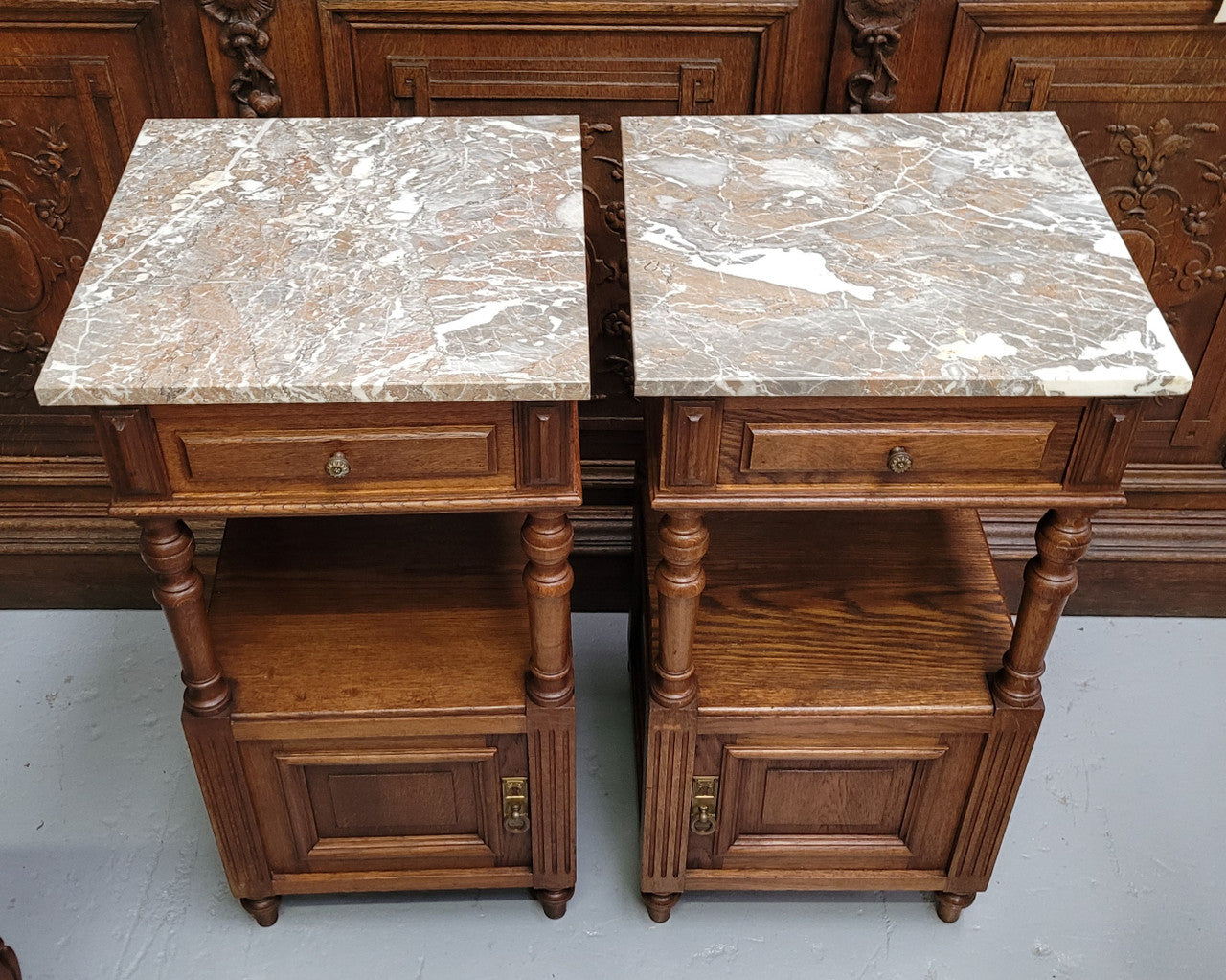 Pair of French Antique Oak marble top bedsides Henry II style. They have a drawer, cupboard and an open shelf for all your storage needs. They have been sourced from France and are in good original detailed condition.