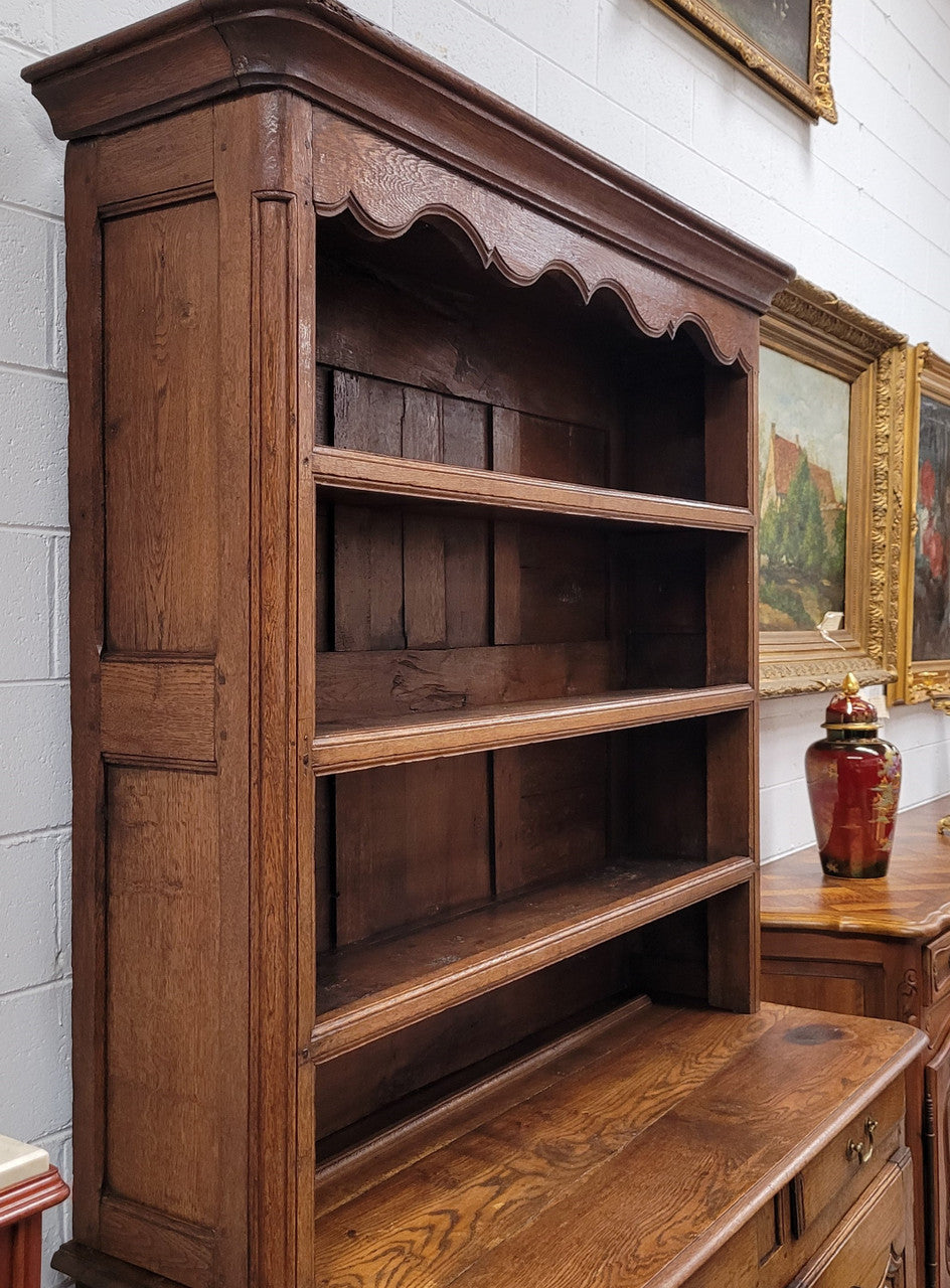 Charming 18th Century French Oak Vaisselier / kitchen dresser with two cupboard doors and three open shelves at the top. Sourced from France and in good original detailed condition.