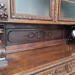 Grand French Oak Gothic style buffet with amazing detailed carvings. This stunning buffet has a display section at the top with two adjustable shelves, two drawers in the middle with elegantly carved handles and storage below with one fixed shelf. It is in good original detailed condition.