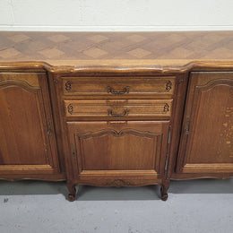 French Louis XV style parquetry top three door sideboard with two drawers. Plenty of storage space with a shelf behind each door. It is in good original detailed condition.