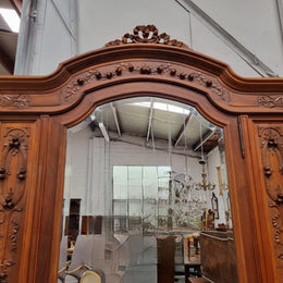 Imposing Louis XV style single mirrored door Walnut armoire. Features deep carved decoration, two interior drawers and three adjustable shelves. It is in good original detailed condition and has been sourced from France.