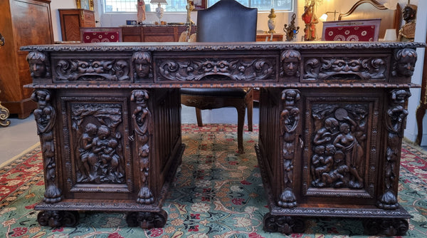 Beautifully carved French Oak early 19th century pedestal desk with 3 drawers, two cupboards and a secret cupboard on the side. There is also a lovely burgundy tooled leather top. In good original detailed condition.