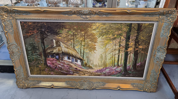 Vintage French oil painting on canvas in original gilt frame of "Forest Cottage Scene". Circa 1950's.