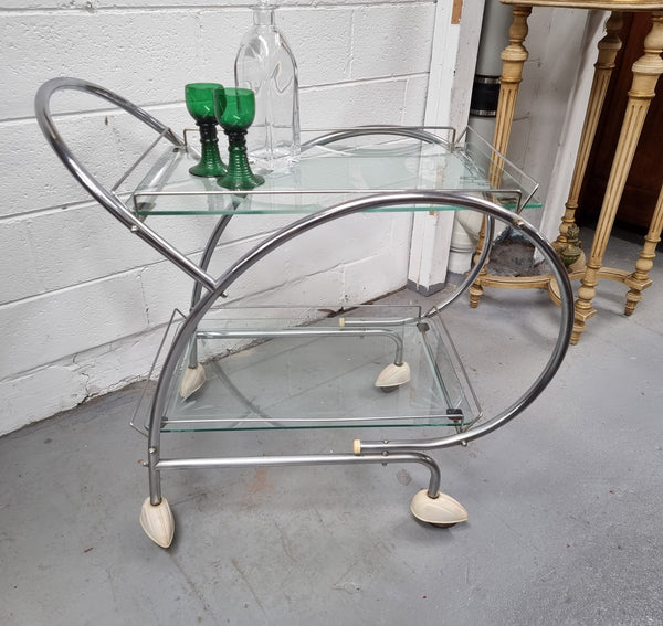 Stylish Art Deco chrome & frosted glass drinks trolley. Bakelite guards on the wheels. It is in good original condition and has been sourced locally.