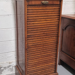 Antique Edwardian roll top Tambour file cabinet desk. This practical antique tambour front filing cabinet dates around 1900 in the Edwardian period and is constructed from Oak. This antique cabinet has an adjustable writing slope, above a tambour front with key and working lock. It has been sourced locally and is in good original detailed condition.