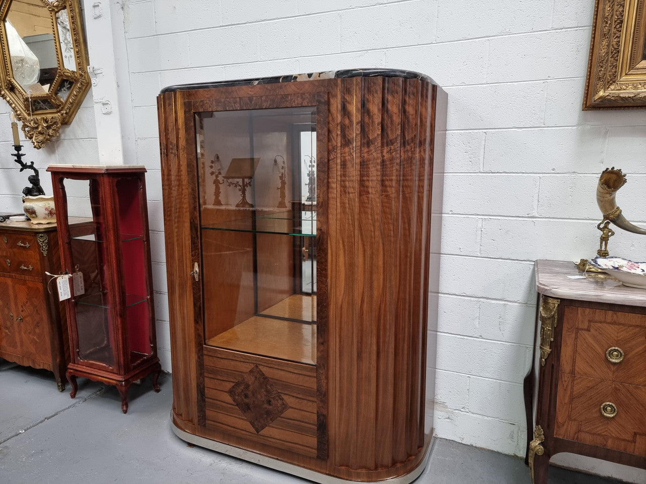 Stunning French Art Deco figured Walnut with Portoro marble top cocktail cabinet. Features chrome trim on base and glass display in door. It is in fully restored condition.