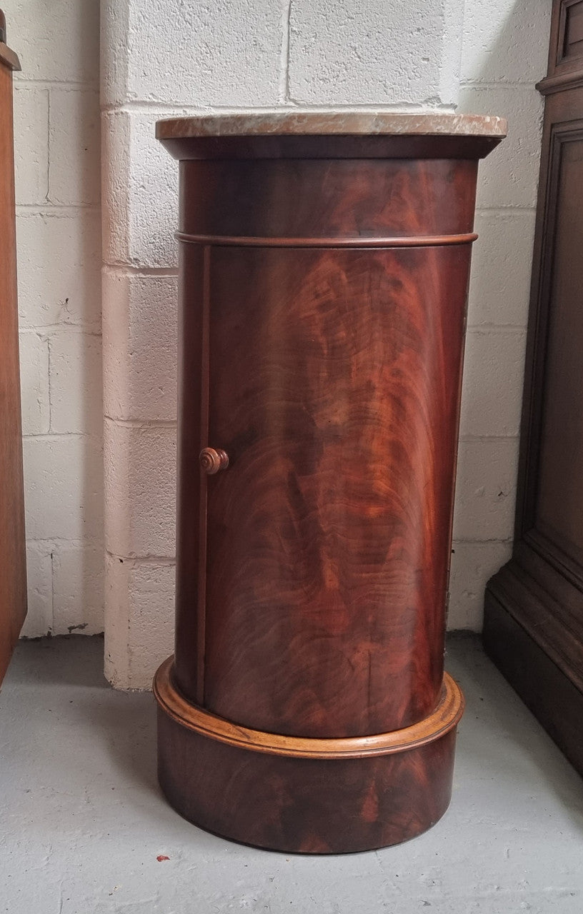 Unusual Empire flame Mahogany cylindrical marble topped bedside/pedestal. Would make an ideal pedestal with added storage inside or could be used as a bedside. Sourced from France and is in good original detailed condition.