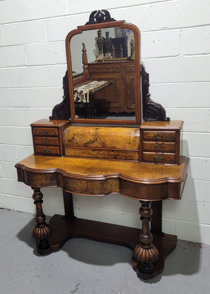 An elegant Victorian Figured Walnut dressing table with tilit mirror and a stunning fine Firgured Walnut serpentine shaped front. It has been sourced locally and is in good original detailed condition.