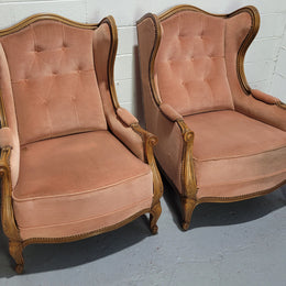 French pair of  Walnut Louis XV style pink upholstered wing back chairs. They are very comfortable to sit in and are of generous portions. The fabric is in good original condition and does have stains and would ideally be reupholstered.