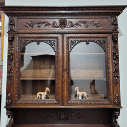 Grand French Oak Gothic style buffet with amazing detailed carvings. This stunning buffet has a display section at the top with two adjustable shelves, two drawers in the middle with elegantly carved handles and storage below with one fixed shelf. It is in good original detailed condition.