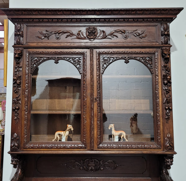 Grand French Oak Gothic style buffet with amazing detailed carvings. This stunning buffet has a display section at the top with two adjustable shelves, two drawers in the middle with elegantly carved handles and storage below with one fixed shelf. It is in good original detailed condition.