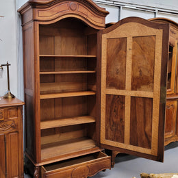 French Louis XV style Walnut armoire with single bevelled mirrored door. It has four adjustable shelves and a hidden exterior drawer at the bottom. It has been sourced from France and is in good original detailed condition.